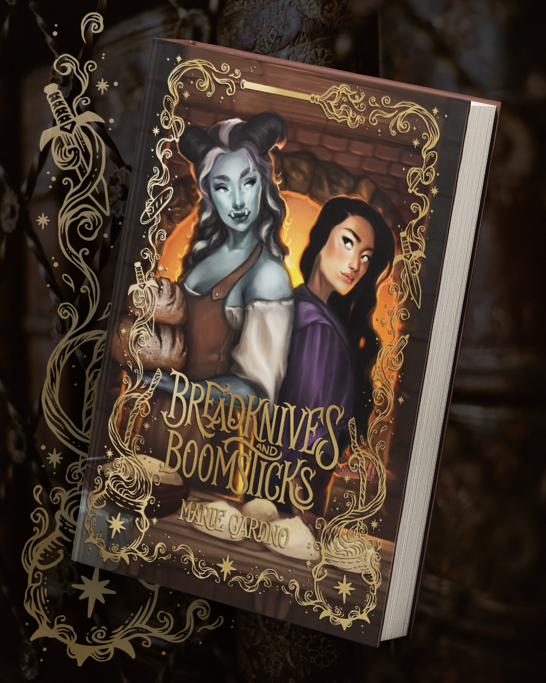 A book mock up of 'Breadknives and Boomsticks' by  Marie Cardno. Shows a  fantasy illustrated cover with two fantasy characters and gold foil effect border illustration. Placed on a blurred bookshelf background with a gold border segment behind with a cauldron and dagger.